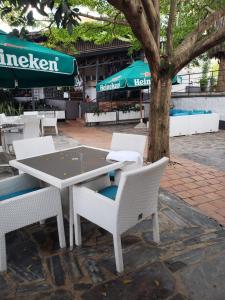 a table and chairs with a table and a tree at La Villa Residence Hotel in Kigali