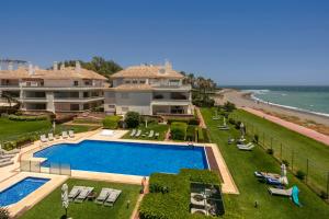 ein großes Haus mit einem Pool am Meer in der Unterkunft Apt 322 Heaven Beach Apartments, Guadalmansa Playa in Estepona