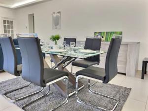 a dining room with a glass table and chairs at CHATENAY 3 in Châtenay-Malabry