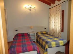a bedroom with two beds and a chandelier at Country House Cunial in Cavaso del Tomba
