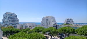 a city skyline with tall buildings and trees at Le Sémaphore - studio climatisé, grande terrasse vue mer - parking, wifi in La Grande Motte