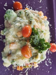 a plate of food with pasta and carrots and broccoli at La Villa Residence Hotel in Kigali