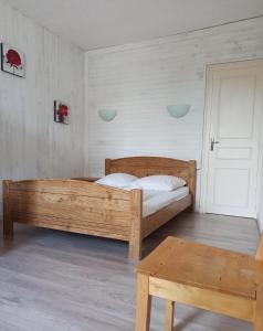 a bedroom with a wooden bed and a table at Gîte La P'tite Fugue in Mareuil-sur-Cher