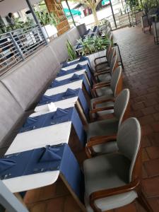 a row of blue tables and chairs on a patio at La Villa Residence Hotel in Kigali