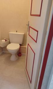 a bathroom with a toilet and a door with red frames at Gîte La P'tite Fugue in Mareuil-sur-Cher