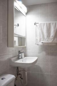 a bathroom with a sink and a toilet and a mirror at Hara's Studio in Perdika