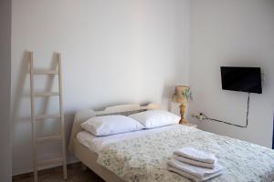 a bedroom with a bed with towels on it at Hara's Studio in Perdika