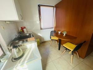 a small kitchen with a table and a sink at City center studio apartment in Malinska