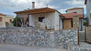 a stone wall in front of a house at Παραθαλάσσιο Studio in Agios Nikolaos