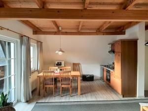 a kitchen and dining room with a table and chairs at Ferienwohnung-Stricker-Typ-B-Balkon-2-2 in Walkenried