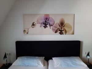 ein Schlafzimmer mit einem Bett und einem Bild von Blumen in der Unterkunft Ferienwohnung Stricker  Typ B, Balkon 2/2 in Walkenried