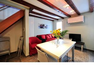 salon ze stołem i czerwoną kanapą w obiekcie Palace La Vida Apartments w Wenecji