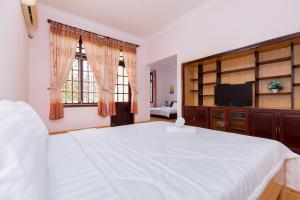 1 dormitorio con 1 cama blanca grande y TV en Victory Villa 82 - Gần Biển Bãi Trước, en Vung Tau