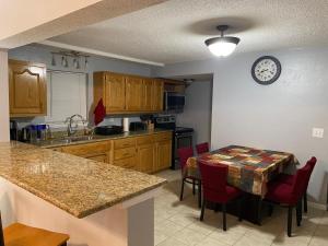 cocina con mesa y reloj en la pared en Cozy house with large free parking on premises en Springfield