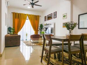 a living room with a dining room table and chairs at Tamu Place 3-Bedroom Serviced Apartment with Pool in Kuala Terengganu