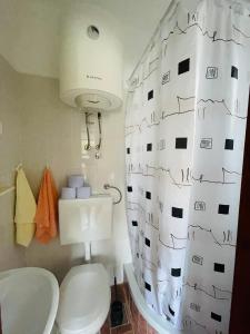 a bathroom with a toilet and a shower curtain at City center studio apartment in Malinska