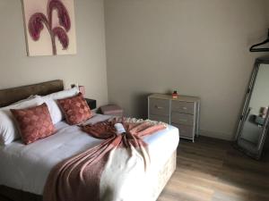 a bedroom with a bed with a dresser and a mirror at Ocean View Apartments - Mayfair in Blackpool