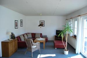 una sala de estar con un sofá y una mesa en Ferienwohnung-Stricker-2-1-Typ-B-Terrasse, en Walkenried