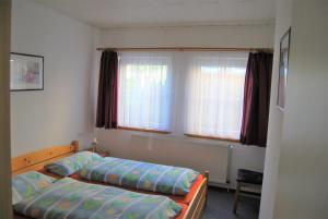 Un dormitorio con dos camas y una ventana. en Ferienwohnung-Stricker-2-1-Typ-B-Terrasse, en Walkenried