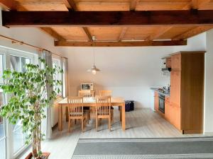 Una cocina y un comedor con mesa y sillas de madera. en Ferienwohnung-Stricker-B-Balkon-1-2, en Walkenried