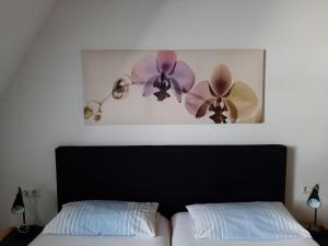 1 dormitorio con 1 cama y una foto de flores en Ferienwohnung-Stricker-B-Balkon-1-2, en Walkenried