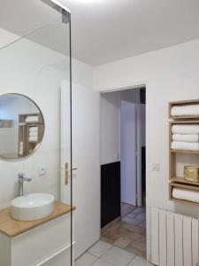 La salle de bains est pourvue d'un lavabo et d'un miroir. dans l'établissement Longère indépendante avec terrain de tennis privé, à Saint-Maugan