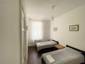 リヴィウにあるOld Lviv Apartmentのベッド2台と窓が備わる客室です。