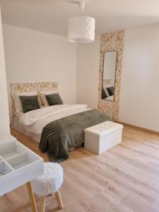 um quarto branco com uma cama e um espelho em Longère indépendante avec terrain de tennis privé em Saint-Maugan