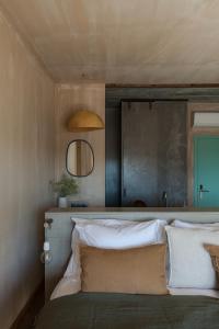 a bedroom with a bed with a wooden headboard and a mirror at Azenhas do Mar Valley House in Sintra