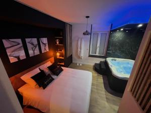 uma casa de banho com uma cama e uma banheira em CK Suite & Spa Reims em Reims