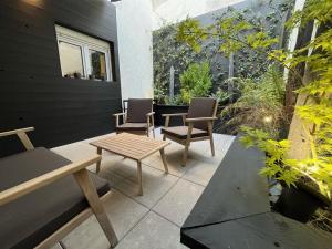 patio z 2 krzesłami, stołem i ławką w obiekcie CK Suite & Spa Reims w mieście Reims