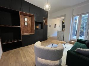 CK Suite & Spa Reims في رانس: غرفة معيشة مع أريكة وطاولة