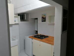 una piccola cucina bianca con piano cottura e lavandino di Gallery House a Fermo