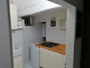 małą białą kuchnię z kuchenką i zlewem w obiekcie Gallery House w mieście Fermo