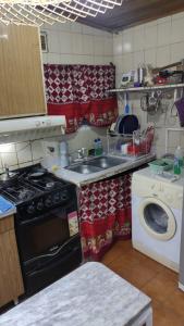 a kitchen with a stove and a washing machine at Cabaña para disfrutar en cualquier ocasión. in Burzaco