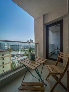 uma mesa e cadeira numa varanda com vista em VR2 Central Apartment em Bucareste