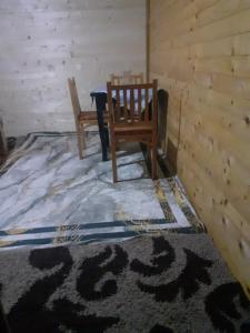 Pokój z 2 drewnianymi krzesłami i dywanem w obiekcie Guesthouse Dioni w mieście Valbonë
