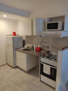 a small kitchen with a stove and a refrigerator at Dpto de 1 dormitorio en el centro de la ciudad in Rosario