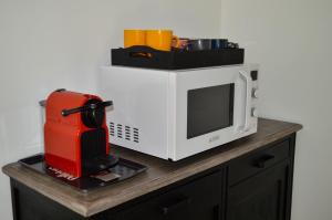 a red and white microwave sitting on top of a counter at Grande Chambre d'hôte Les Chats-Pîtres in La Rochette