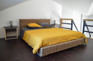 una camera con letto e copriletto giallo di Grande Chambre d'hôte Les Chats-Pîtres a La Rochette