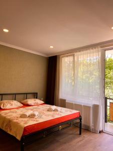 um quarto com uma cama e uma grande janela em Woodland Borjomi em Borjomi