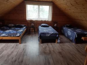 a room with two beds in a log cabin at Väike-Puusmetsa puhkemaja in Valtina