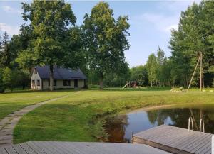 a view of a house and a pond with a playground at Väike-Puusmetsa puhkemaja in Valtina