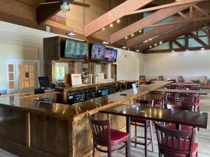 a bar in a restaurant with wooden tables and chairs at Holiday Inn Cape Cod-Falmouth, an IHG Hotel in Falmouth