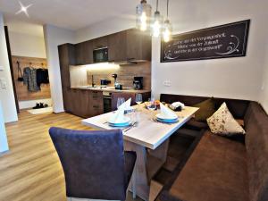 a dining room with a table and a kitchen at Apart Isabella in Schwendau