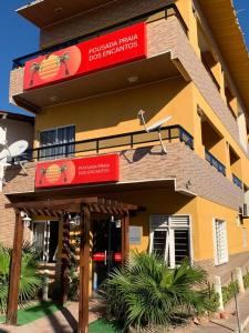 a building with a sign for a dog restaurant at Pousada Praia Dos Encantos in Japaratinga