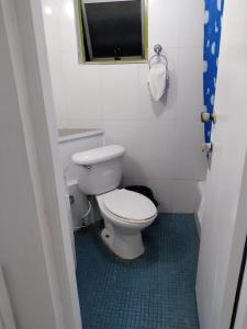 a bathroom with a white toilet and a window at Deluxe Montego Bay Club Studio & Suites in Montego Bay