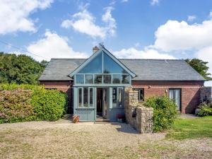 a red brick house with a conservatory at Tyn Morfa in Pwllheli