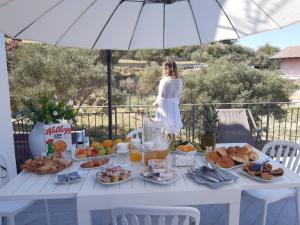 een tafel vol eten met een vrouw op de achtergrond bij Il Fiore Bianco in Capo dʼOrlando