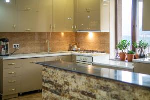 a kitchen with white cabinets and a counter top at Hotel Diamond Kazbegi in Stepantsminda